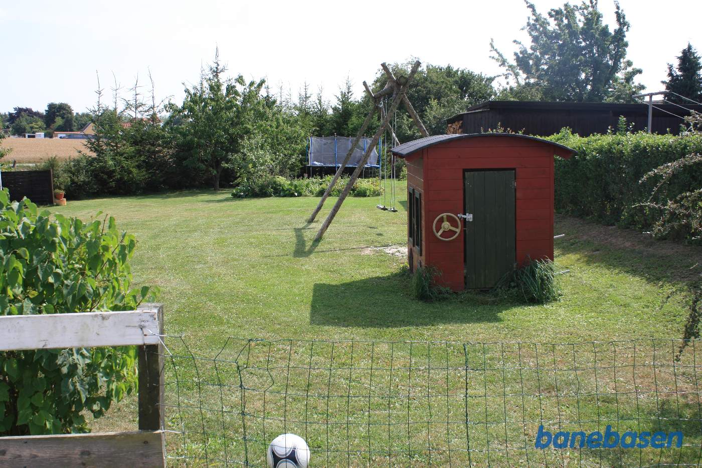 Vi står i markskellet og kigger ind i haven, hvor banen gik. Vi ser i retning mod Aakirkeby