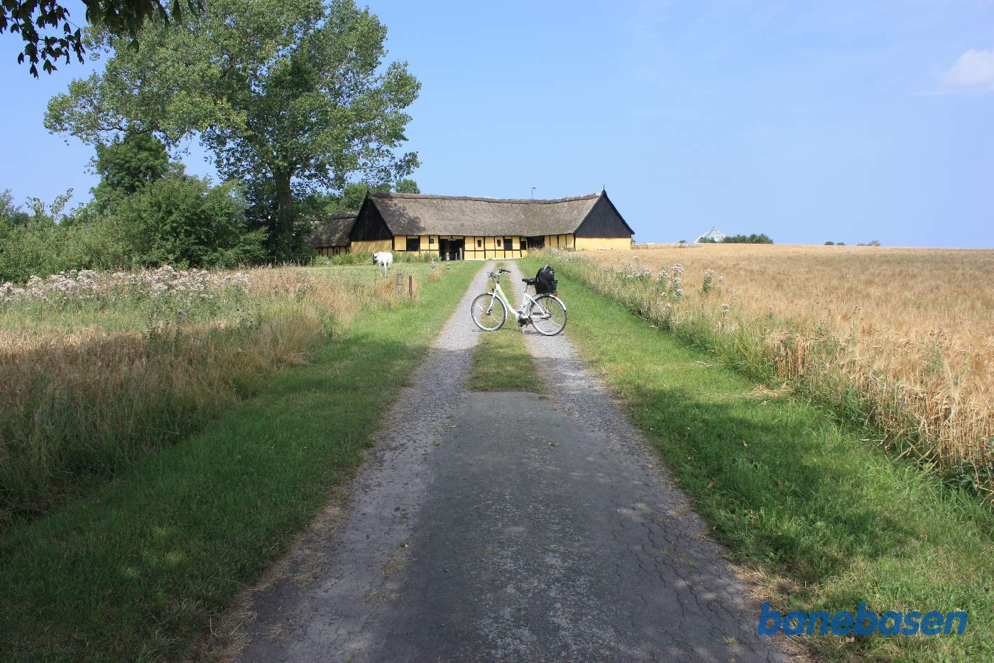 Vi står på jordvejen op til gården, Lille Frigård. Cyklen markerer, hvor banen krydsede vejen. Gudhjem til venstre og Aakirkeby til højre