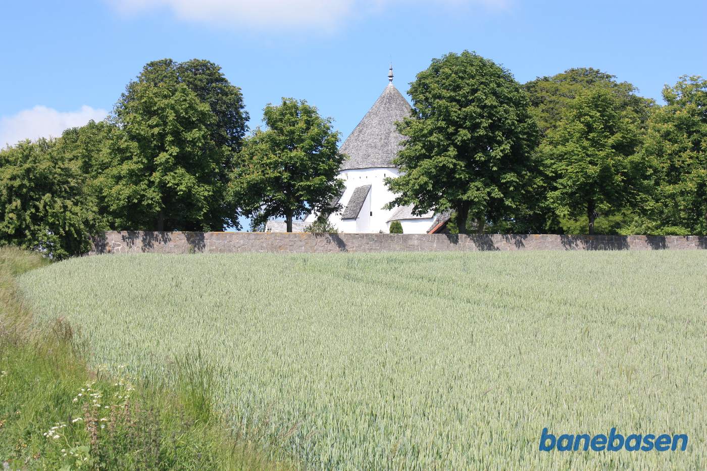 Vi står på banestien og kigger op mod rundkirken, Aakirkeby til venstre og Gudhjem til højre Vi står på banestien og kigger op mod rundkirken, Aakirkeby til venstre og Gudhjem til højre