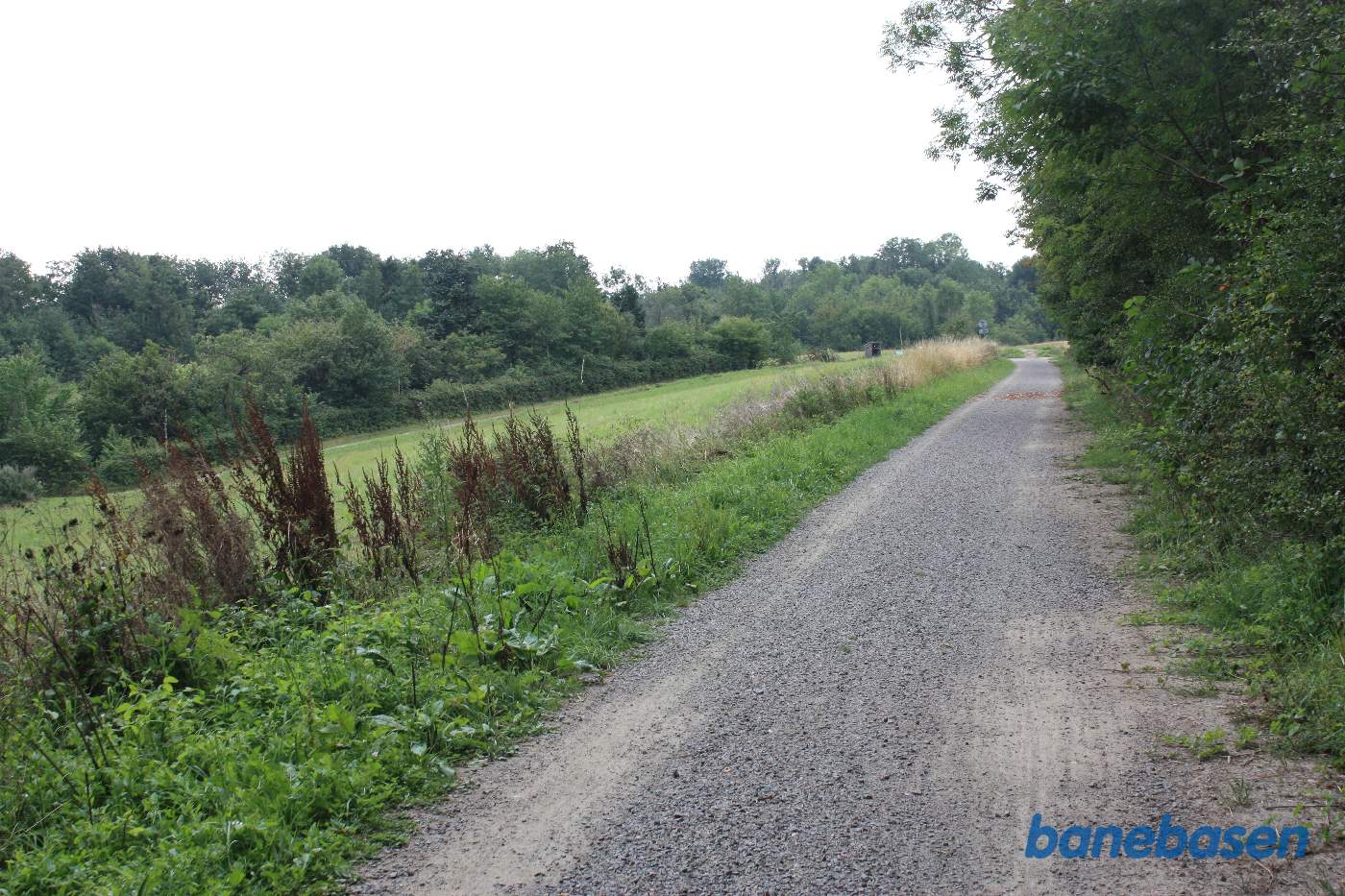 Vi står på banestien og kigger i retning mod Aakirkeby. Østerlars rundkirke ligger inde bag træerne til højre