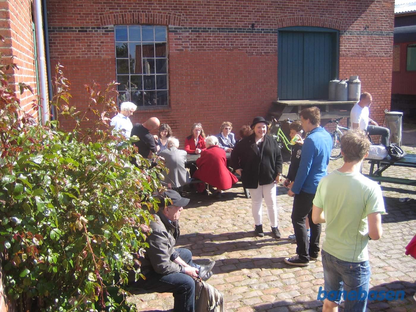 Gæsterne sidde og hygger sig i det fine vejr på stationens forplads