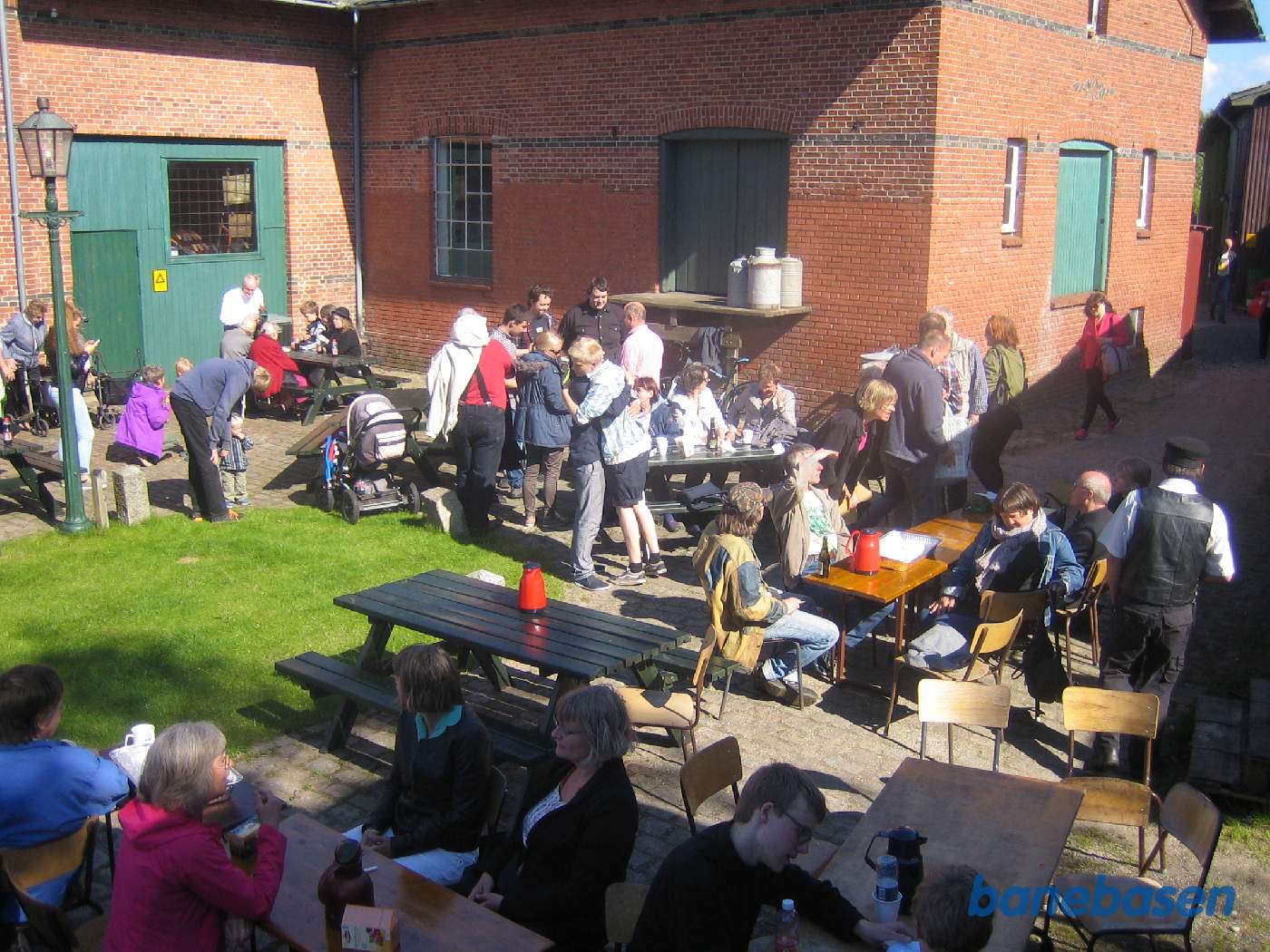 Gæsterne sidde og hygger sig i det fine vejr på stationens forplads