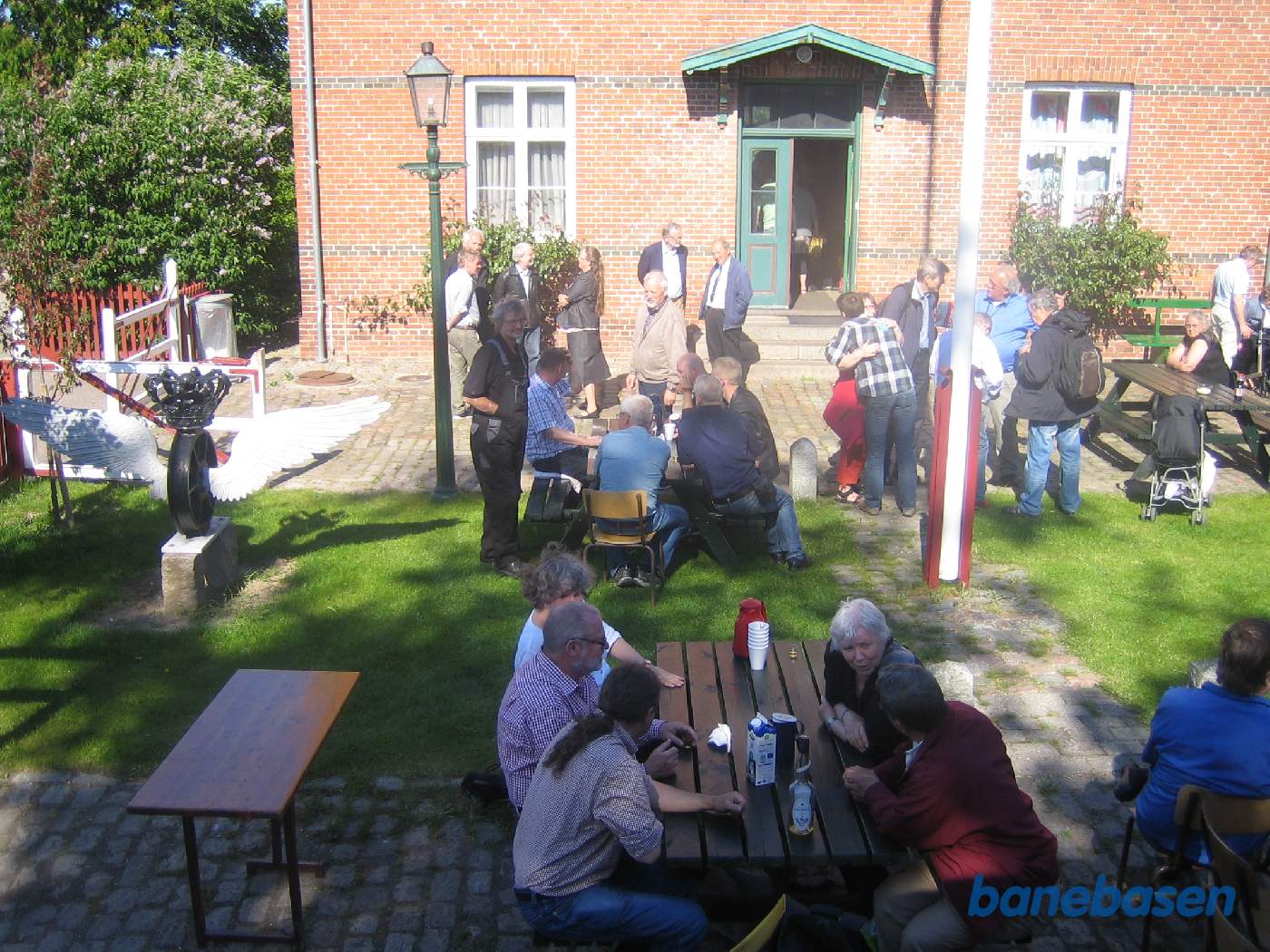 Gæsterne sidde og hygger sig i det fine vejr på stationens forplads Gæsterne sidde og hygger sig i det fine vejr på stationens forplads