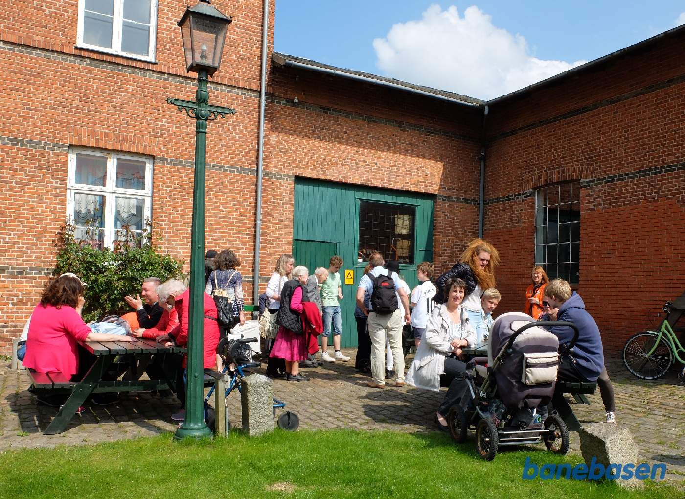 Gæsterne sidde og hygger sig i det fine vejr på stationens forplads