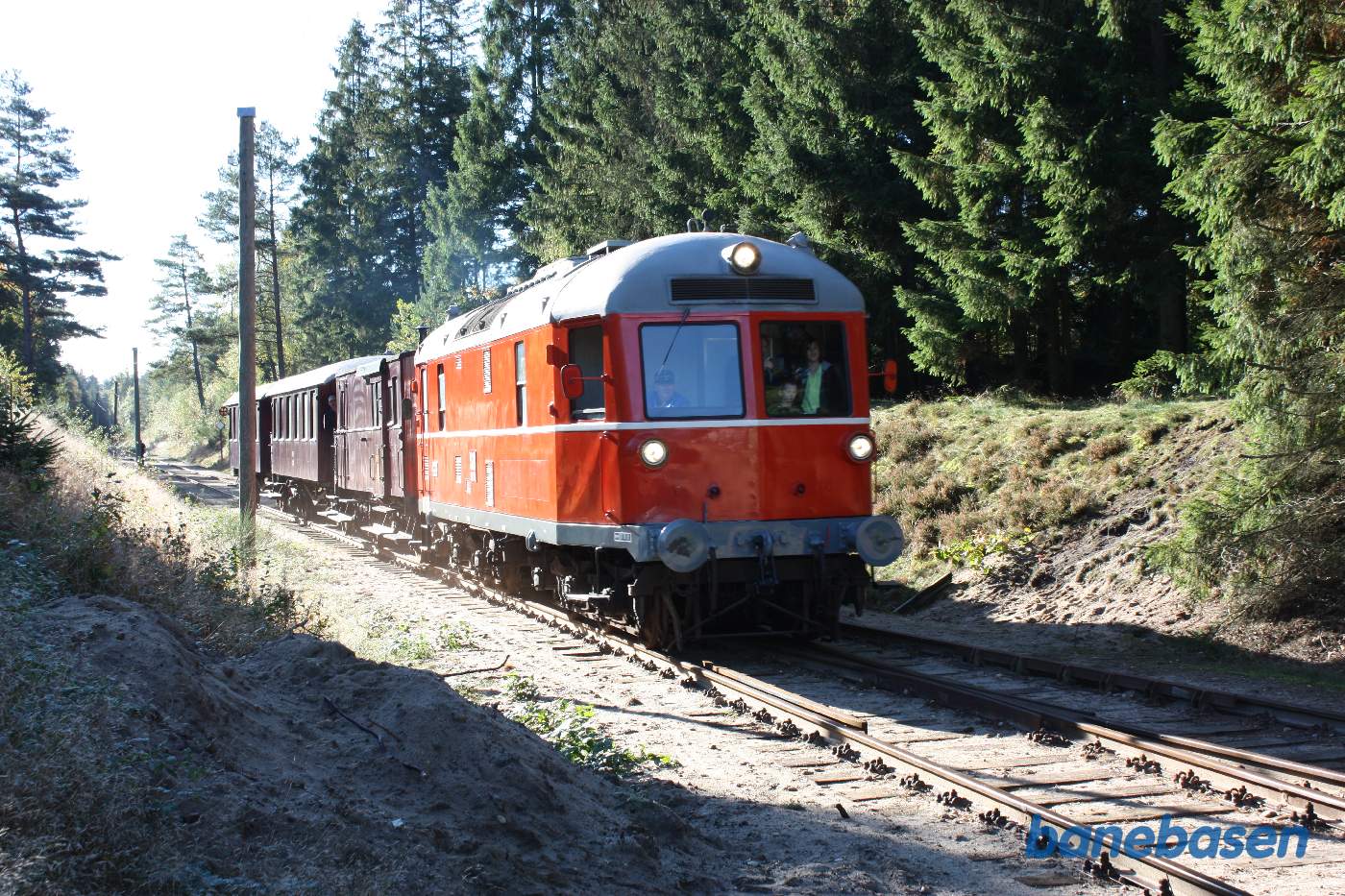 Vi står i indkørselsenden og ser et persontog køre ind på stationen