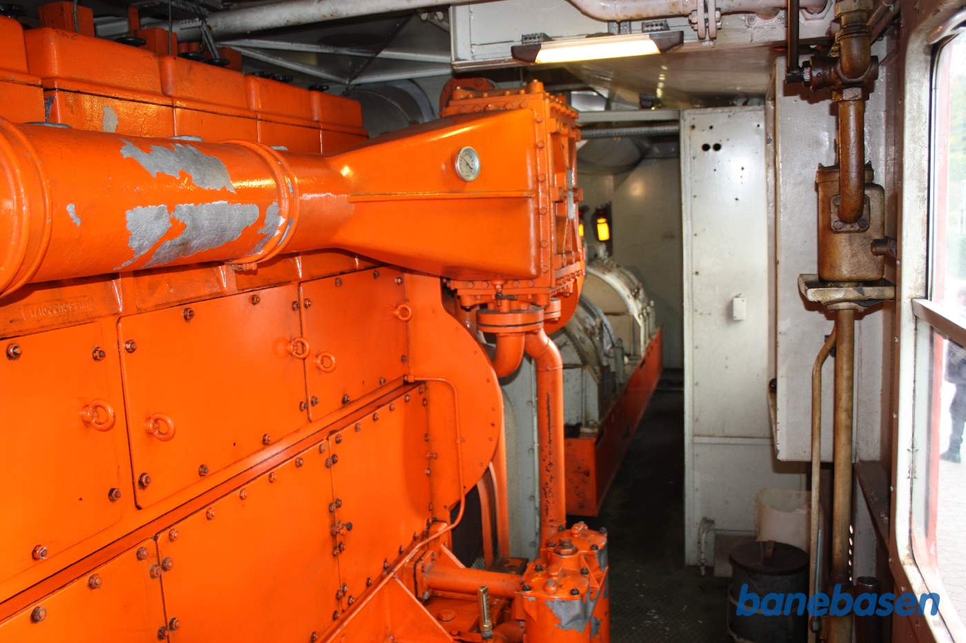 Den store 8 cylindrede Frichs dieselmotor, dynamoerne ses gennem skillevæggen Den store 8 cylindrede Frichs dieselmotor, dynamoerne ses gennem skillevæggen