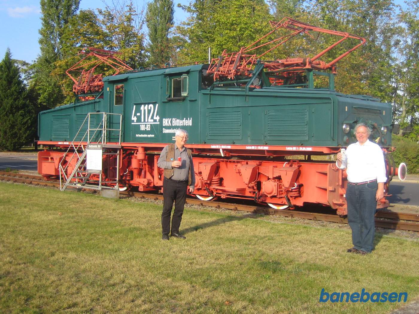 Alstom serverede øl og vand som afslutning på fabriksbesøget. To gæster står foran det store minelokomotiv