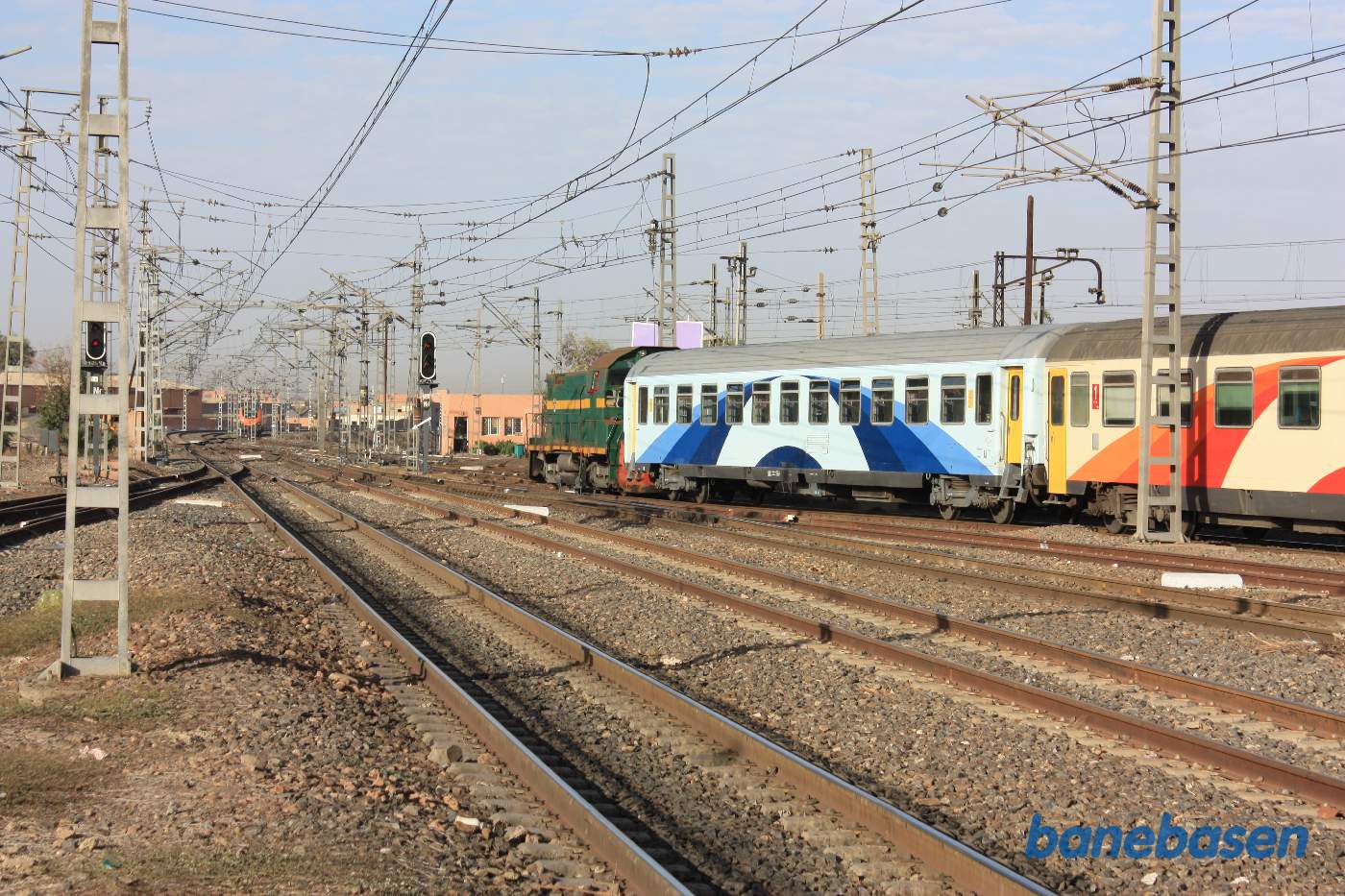 Et grønt diesellokomotiv trækker nogle vogne væk