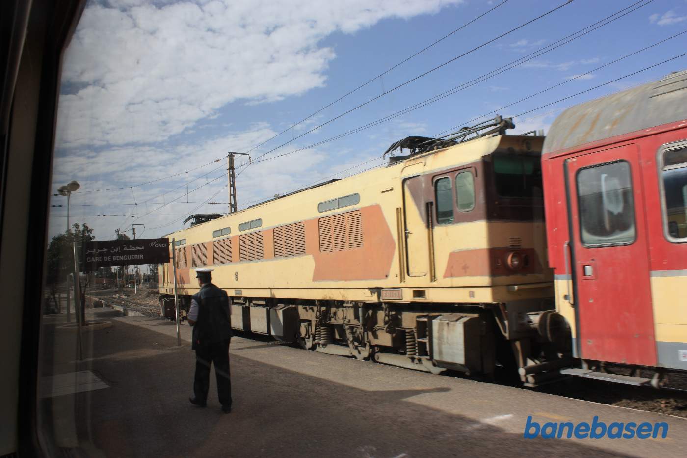 Vi krydser med et modkørende persontog hvor det elektriske lokomotiv har sænket sin strømaftager