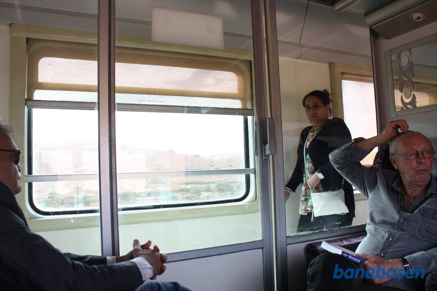 Rejsende i 1.klassesvognens kupé samt en dame i sidegangen