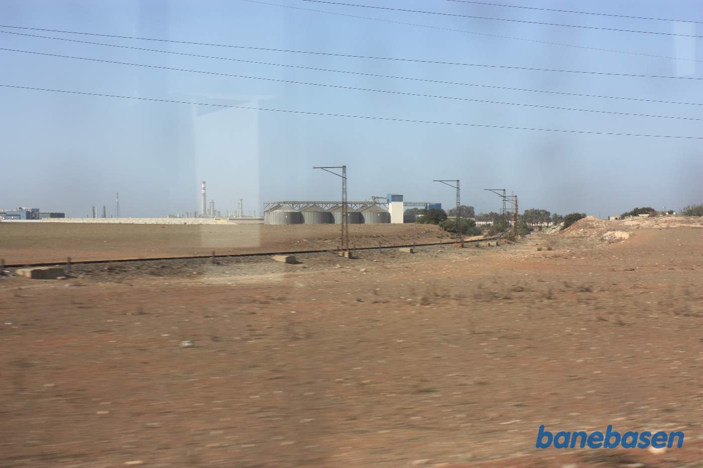 Vi kigger ud langs et fabriksspor, fabrikken ses midt i billedet