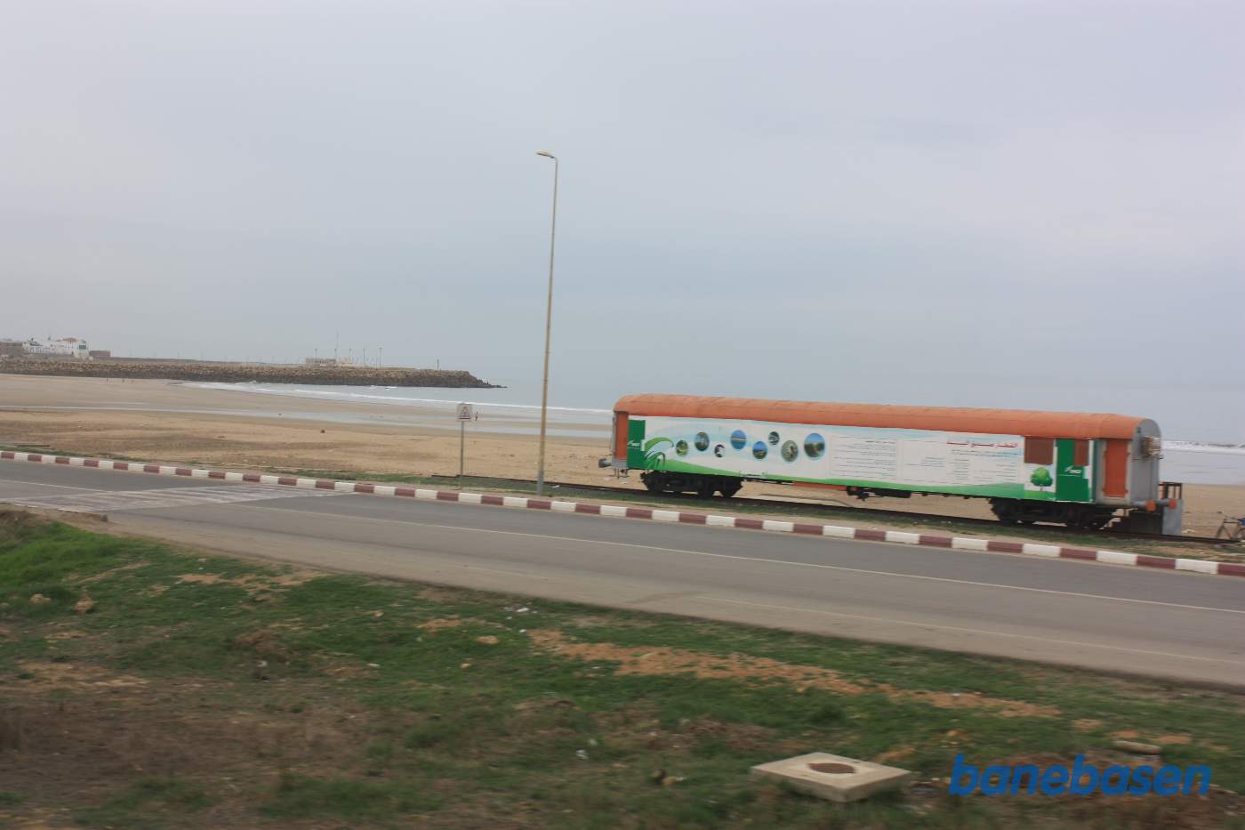 En udstillingsvogn på en sporramme ved havet