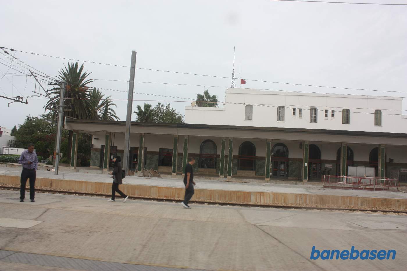 Stationsbygningen set fra perronerne ud gennem et togvindue