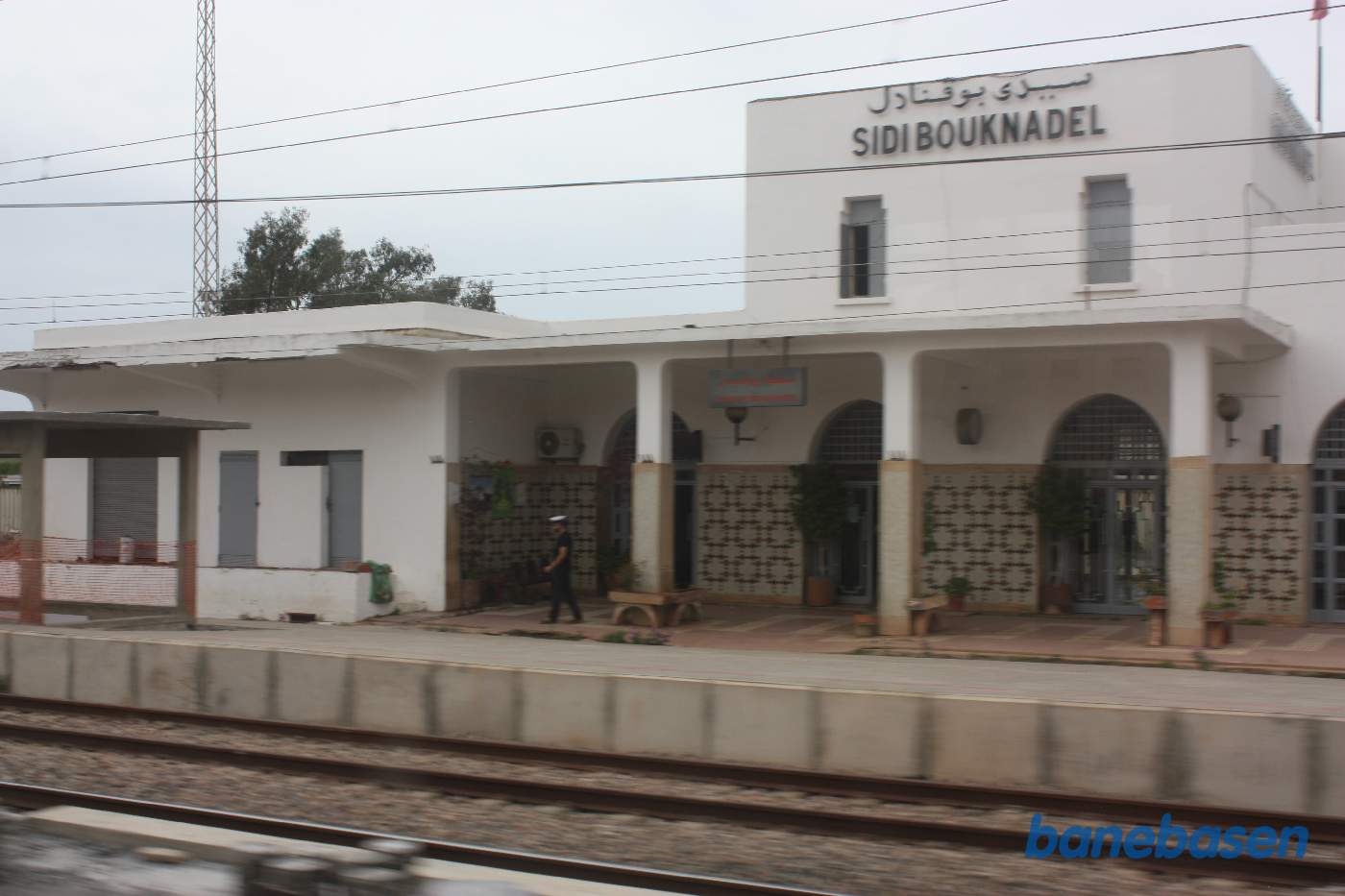 Stationsbygningen set fra perronerne ud gennem et togvindue