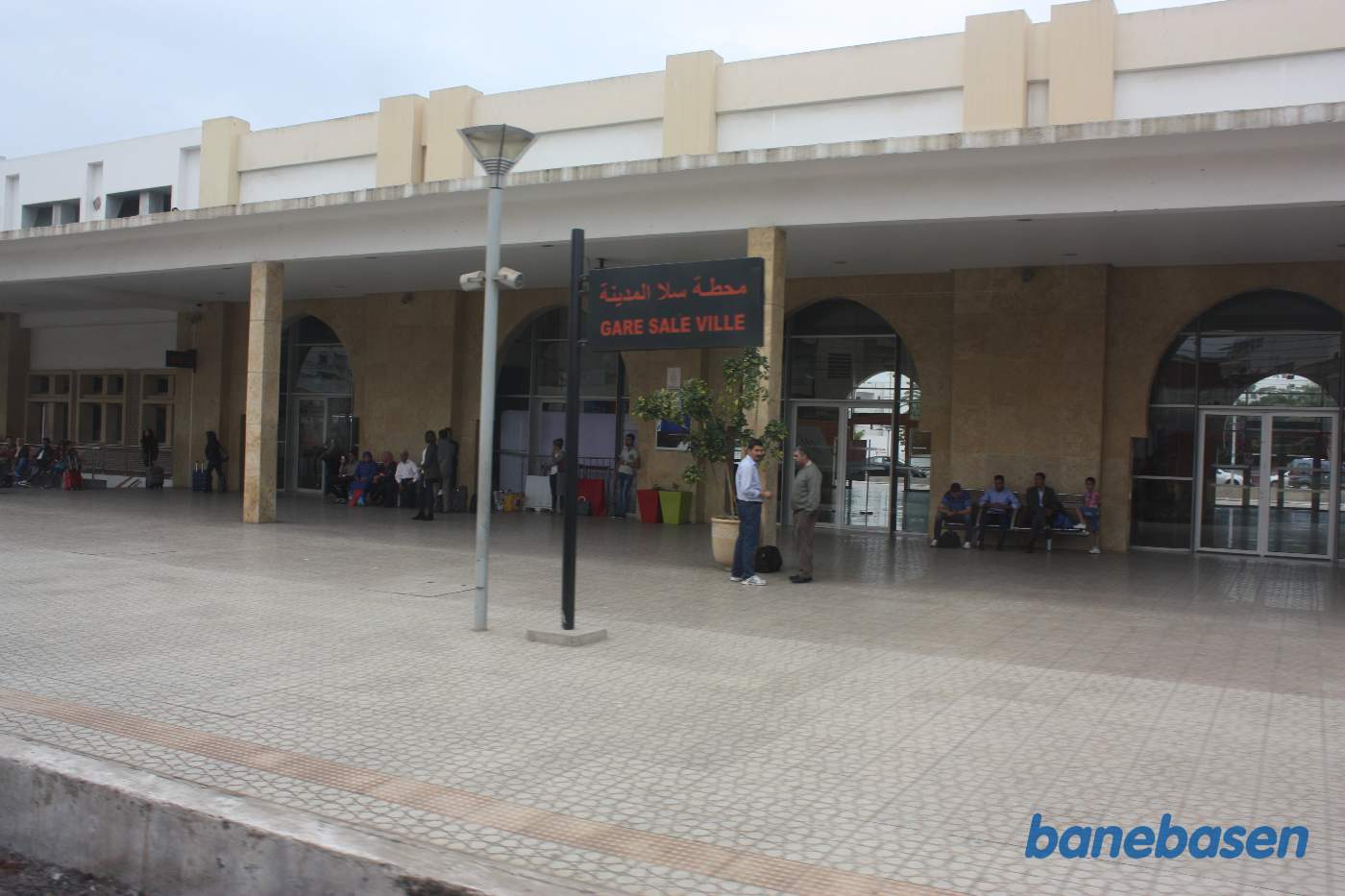 Stationsbygningen set fra perronerne ud gennem et togvindue