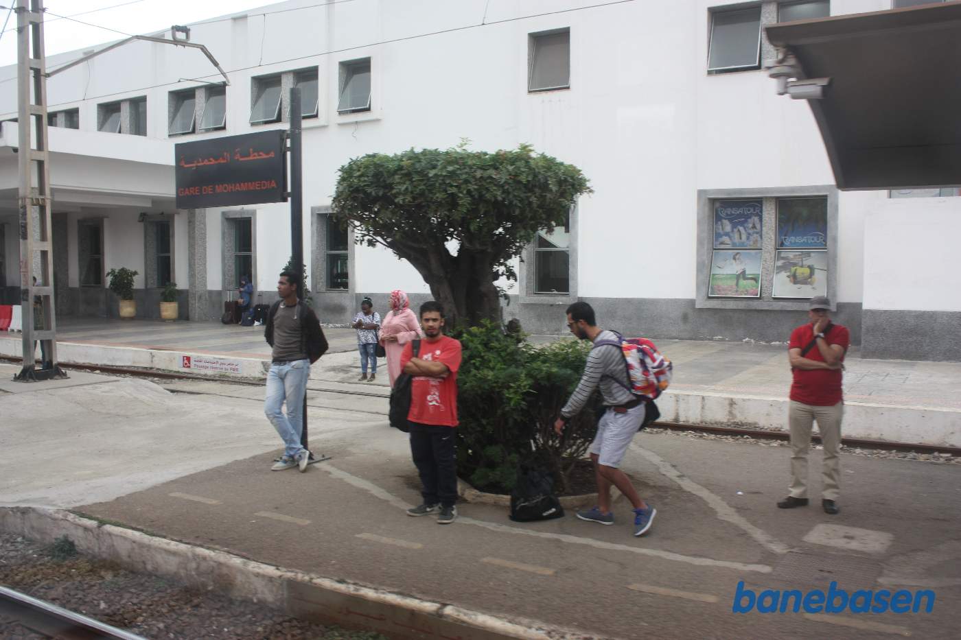 Stationsbygningen set fra perronerne ud gennem et togvindue
