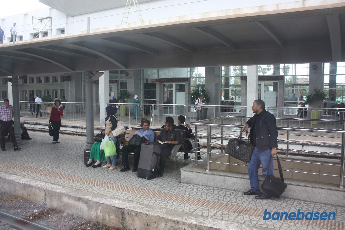 Stationsbygningen set fra perronerne ud gennem et togvindue