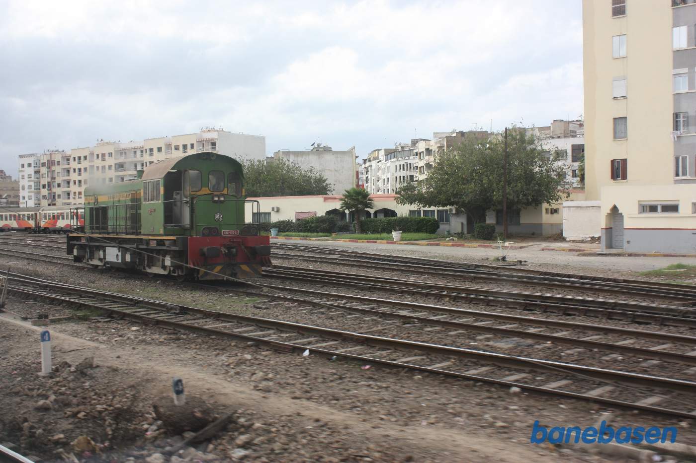 Grønt rangerlokomotiv rangerer, set ud gennem et togvindue