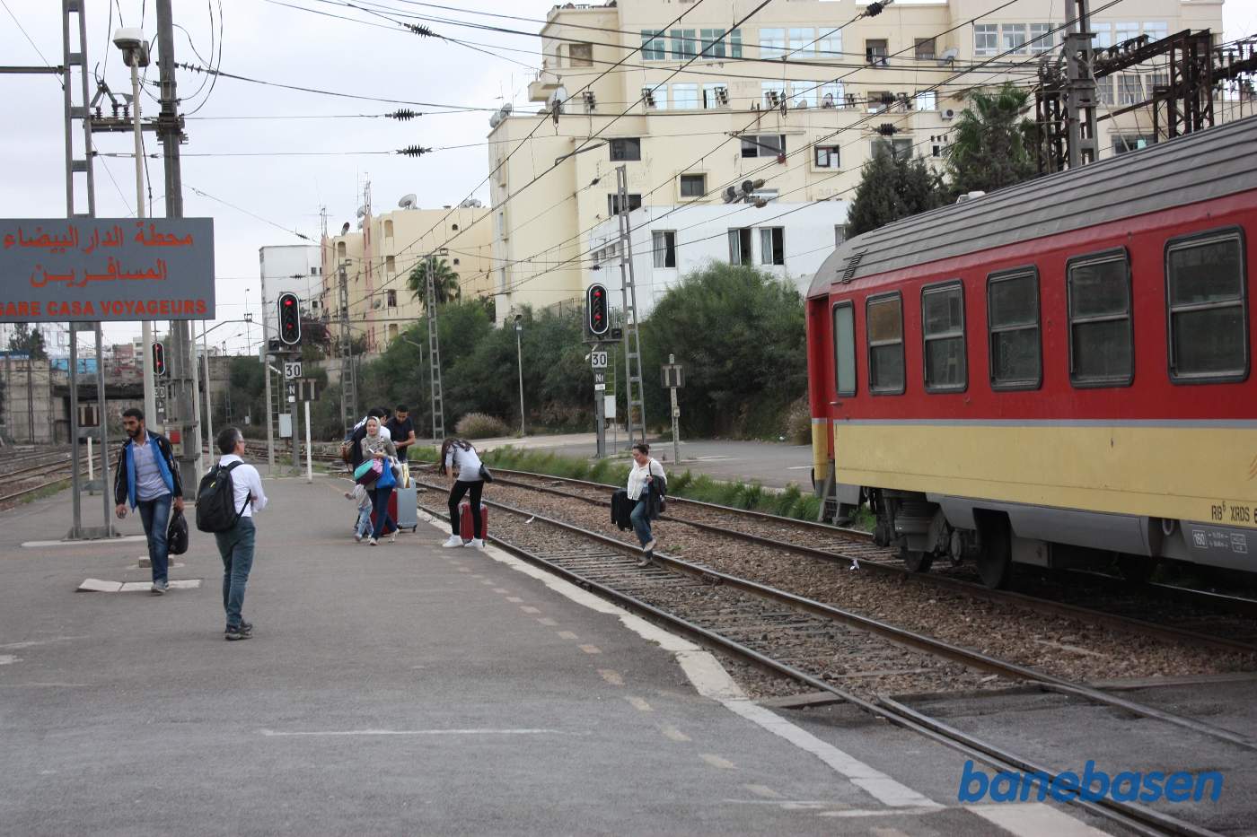 Da toget er for langt og har blokeret overgangen mellem perron 1 og 2, går de rejsende bagom toget med deres bagage
