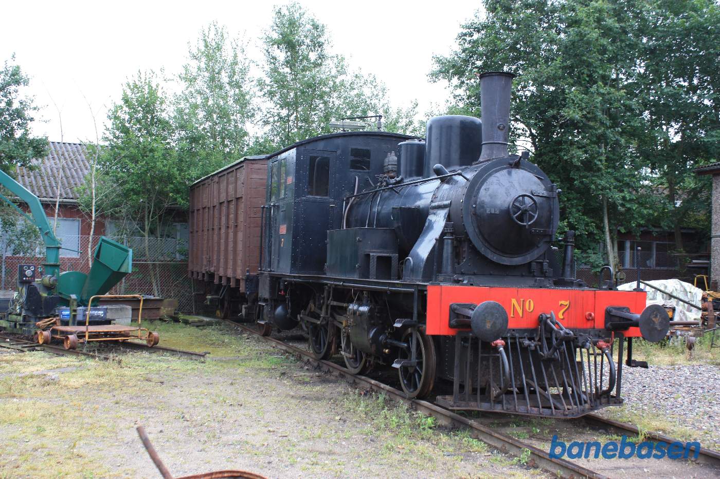 Banens lille damplokomotiv på et sidespor bag remisen