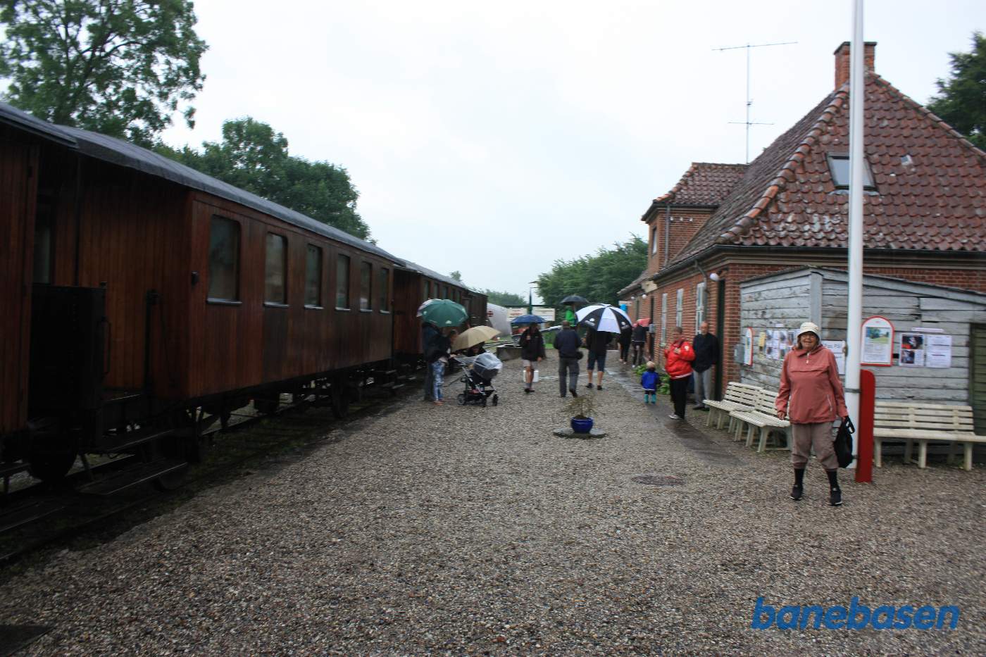Toget holder ved perron, stationsbygningen til højre