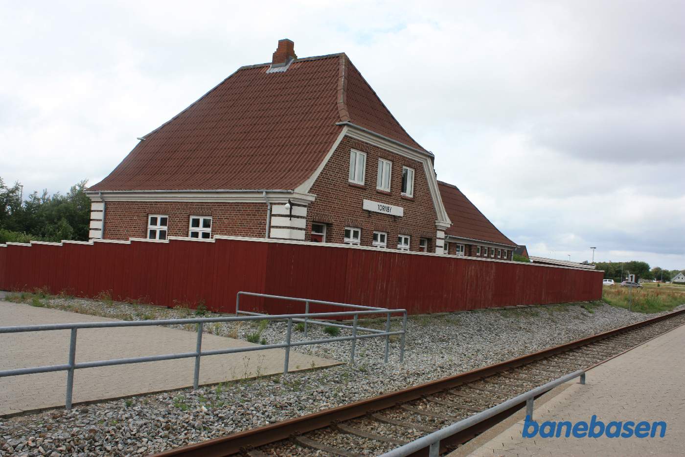 Stationsbygningen gemt inde bag et højt plankeværk