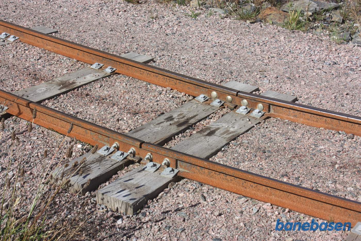 Nærbillede af laskerne i sporet der holder skinnerne sammen