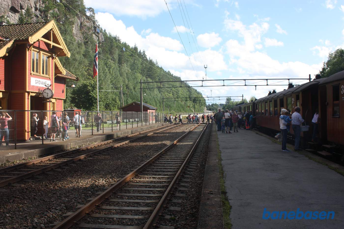 Turisterne stiger på toget, Setesdalsbanens venners stationsbygning ses til venstre
