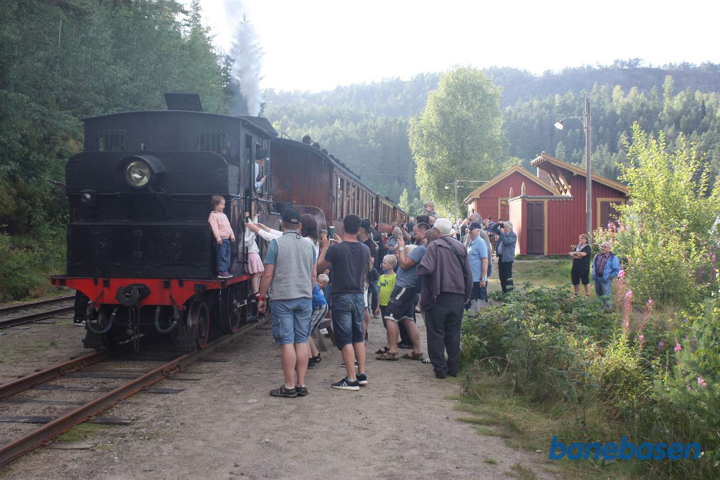 Damplokomotivet koblet til personvognene, gæsterne har travlt med at fotografere