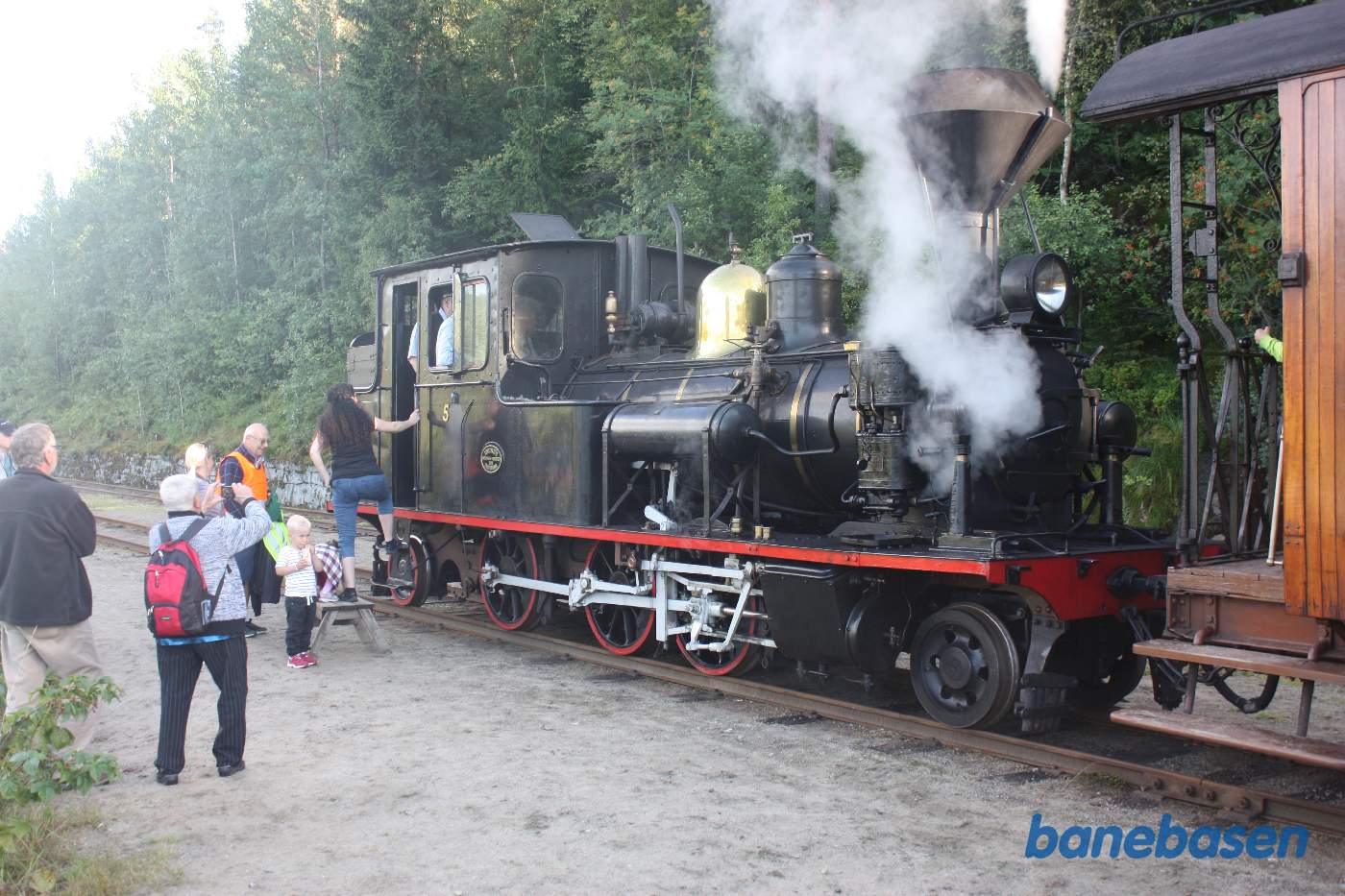 Damplokomotivet koblet til personvognene, gæsterne har travlt med at fotografere