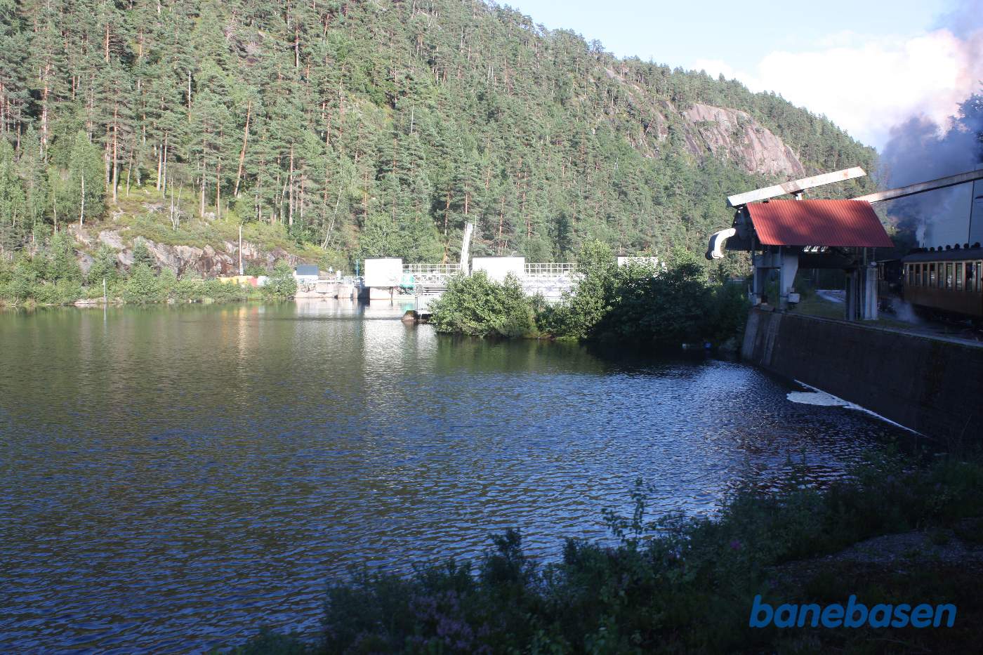 Toget kører langs kanten af søen, vi ser Beihølen dæmningen midt i billedet