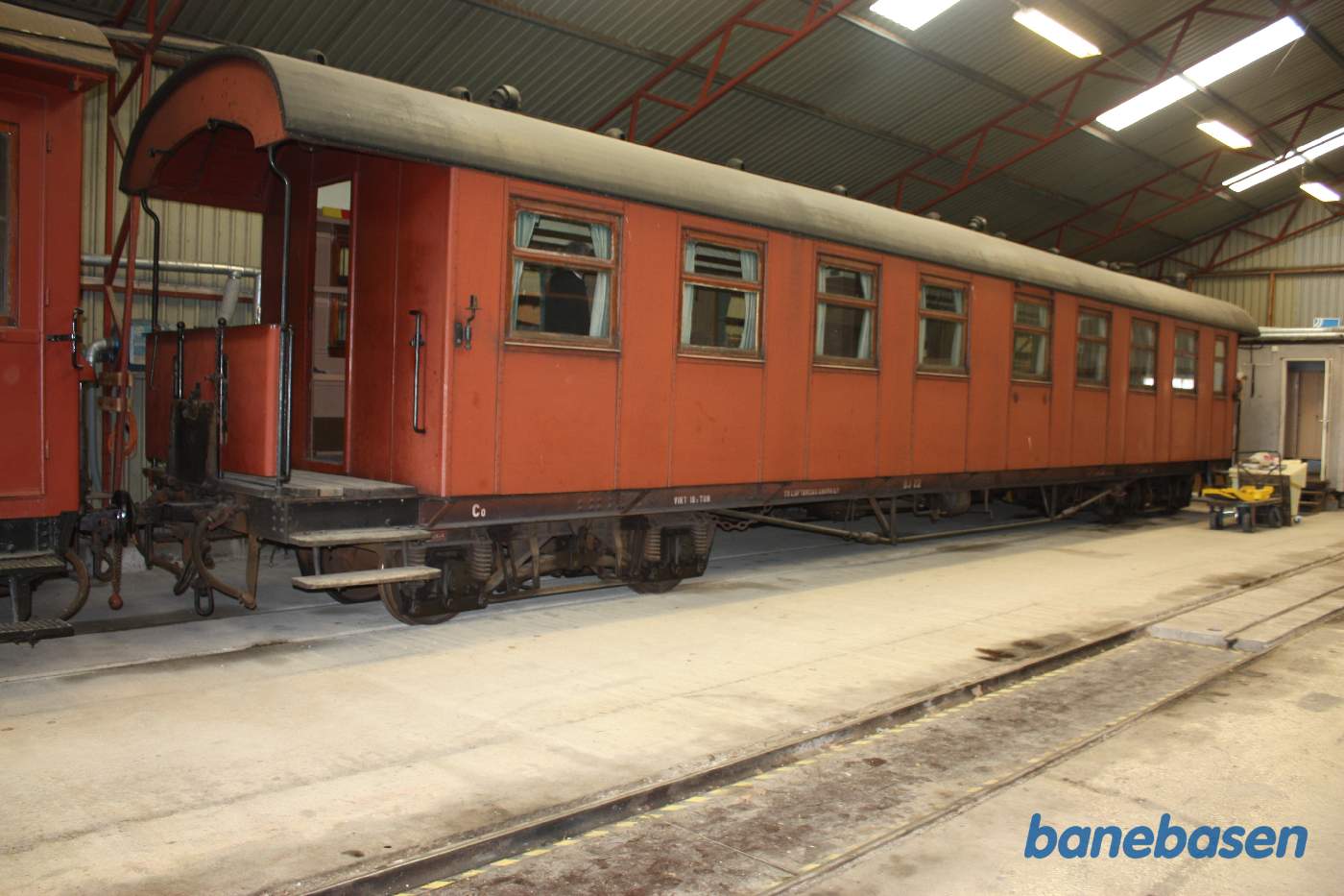 Vi er inde i vognhallen hvor der står en del materiel, her en personvogn