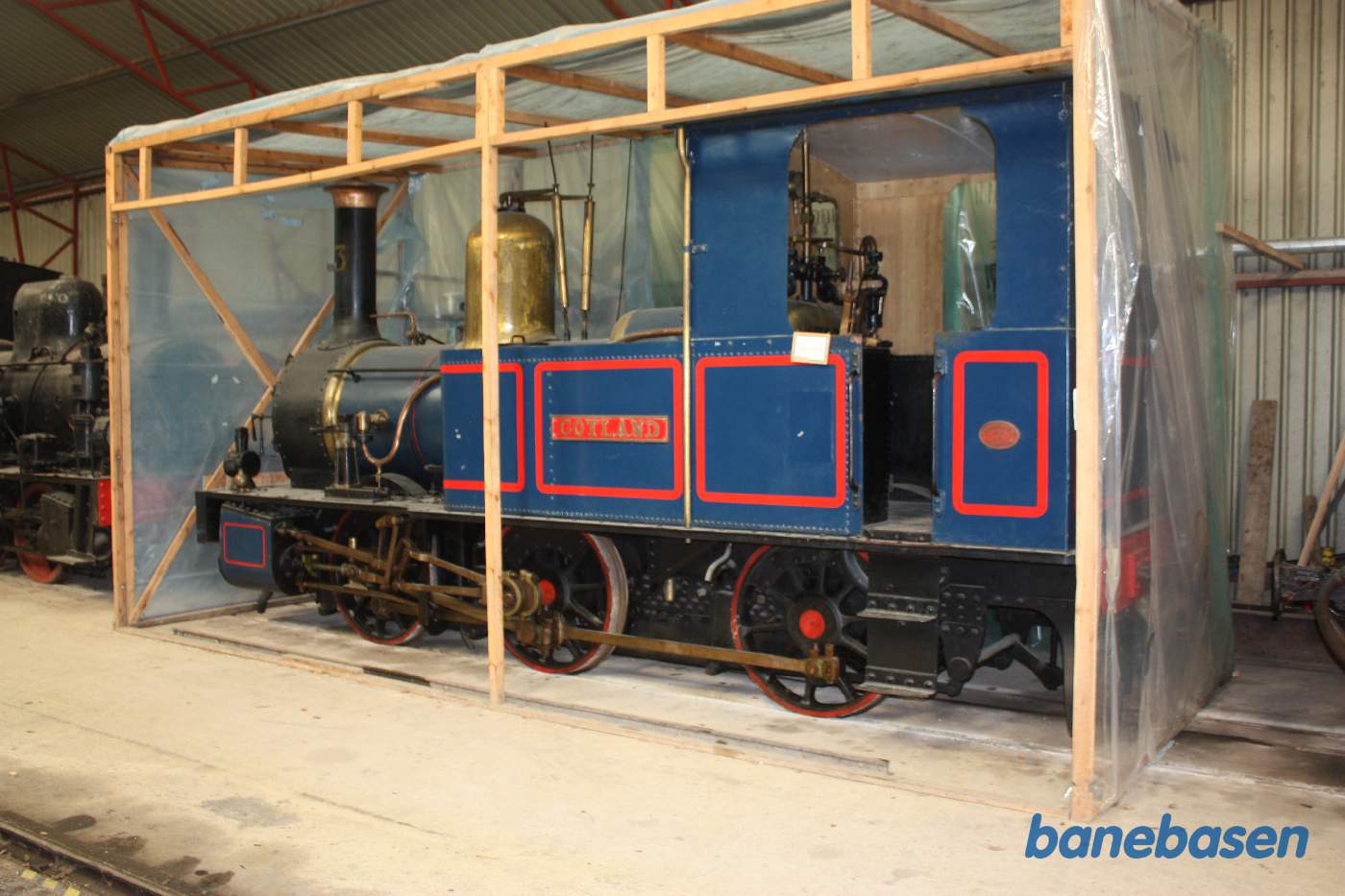 Vi er inde i vognhallen hvor der står en del materiel, her damplokomotivet Gotland pakket ind i plast