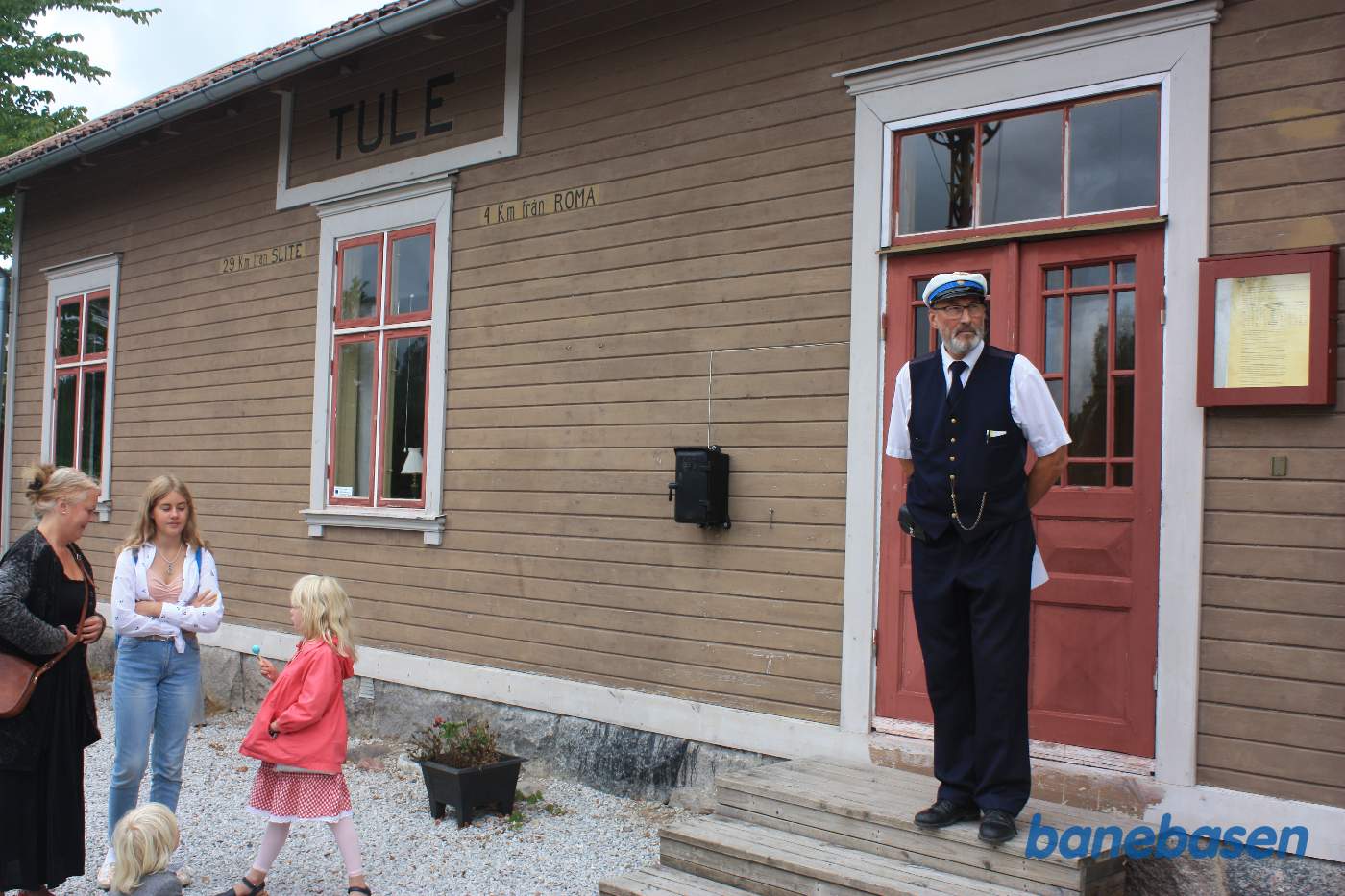 Togføreren står på trappen, klar til at fortælle om banen og stationen