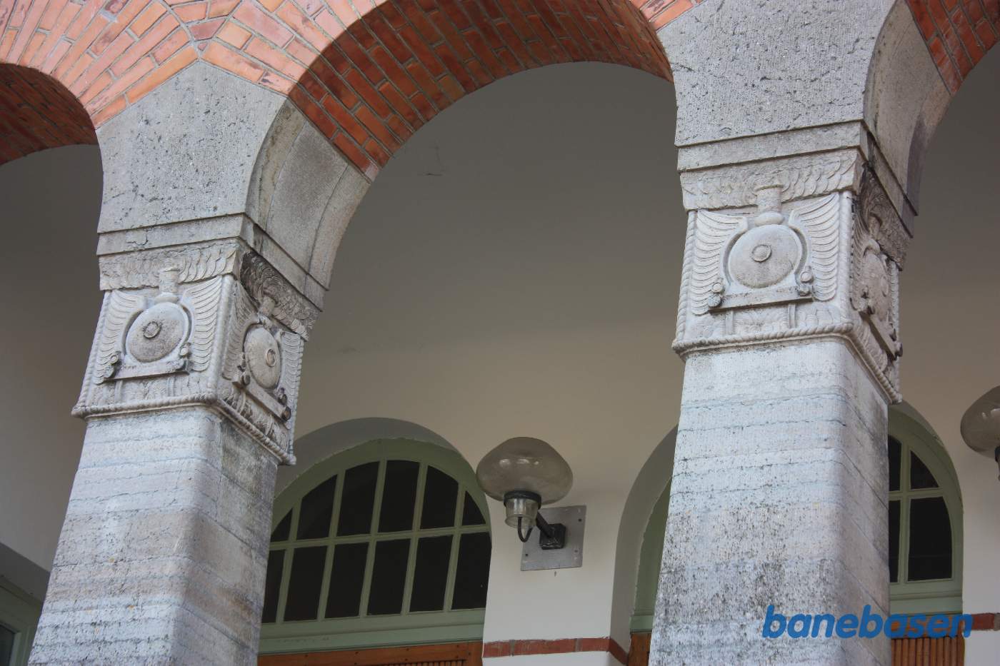 Nærbillede af søjlerne på stationsbygningen, bemærk de udhuggede damplokomotivfronter