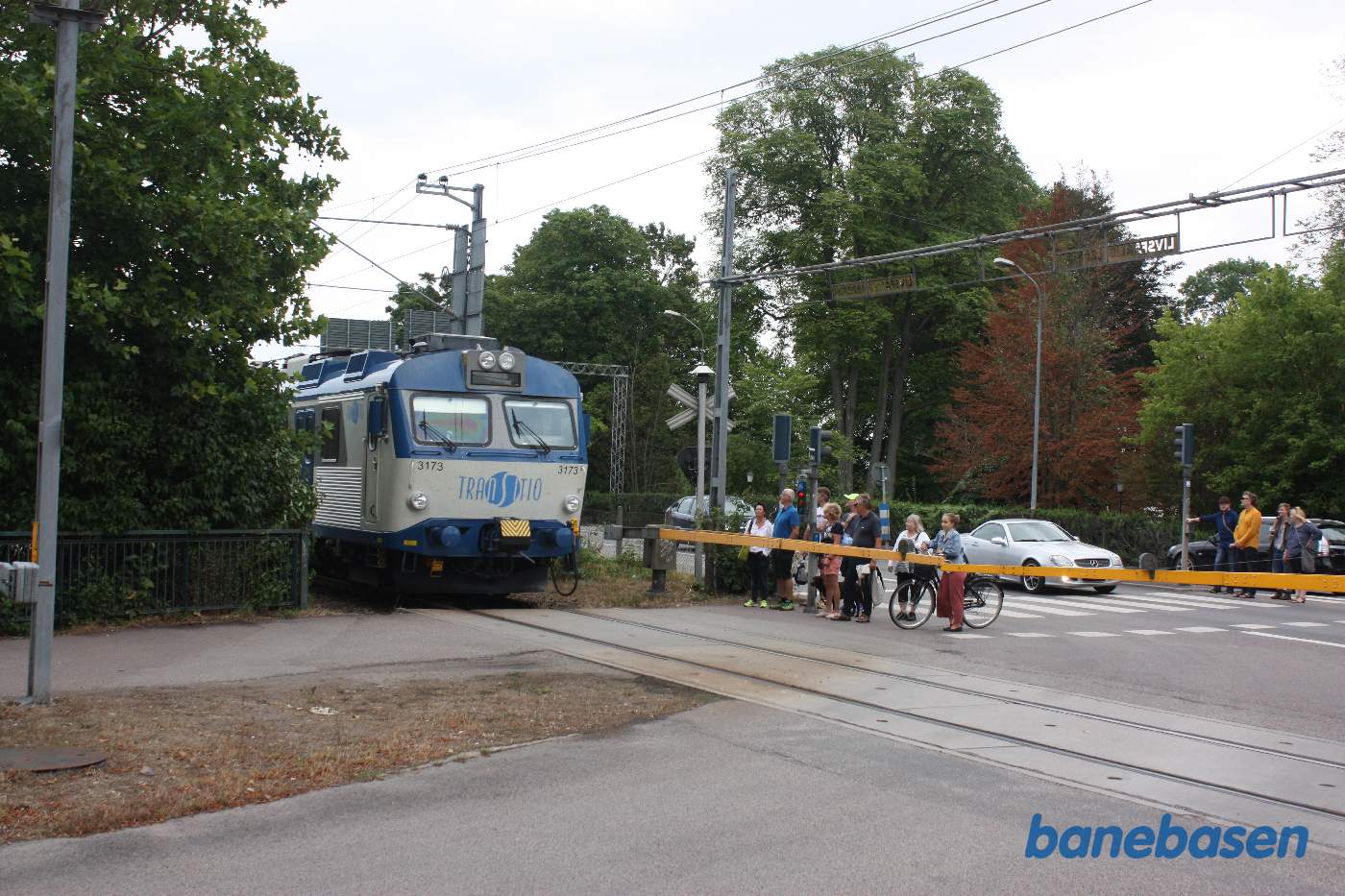 Et lokaltog på vej ind på stationen passerer en overkørsel