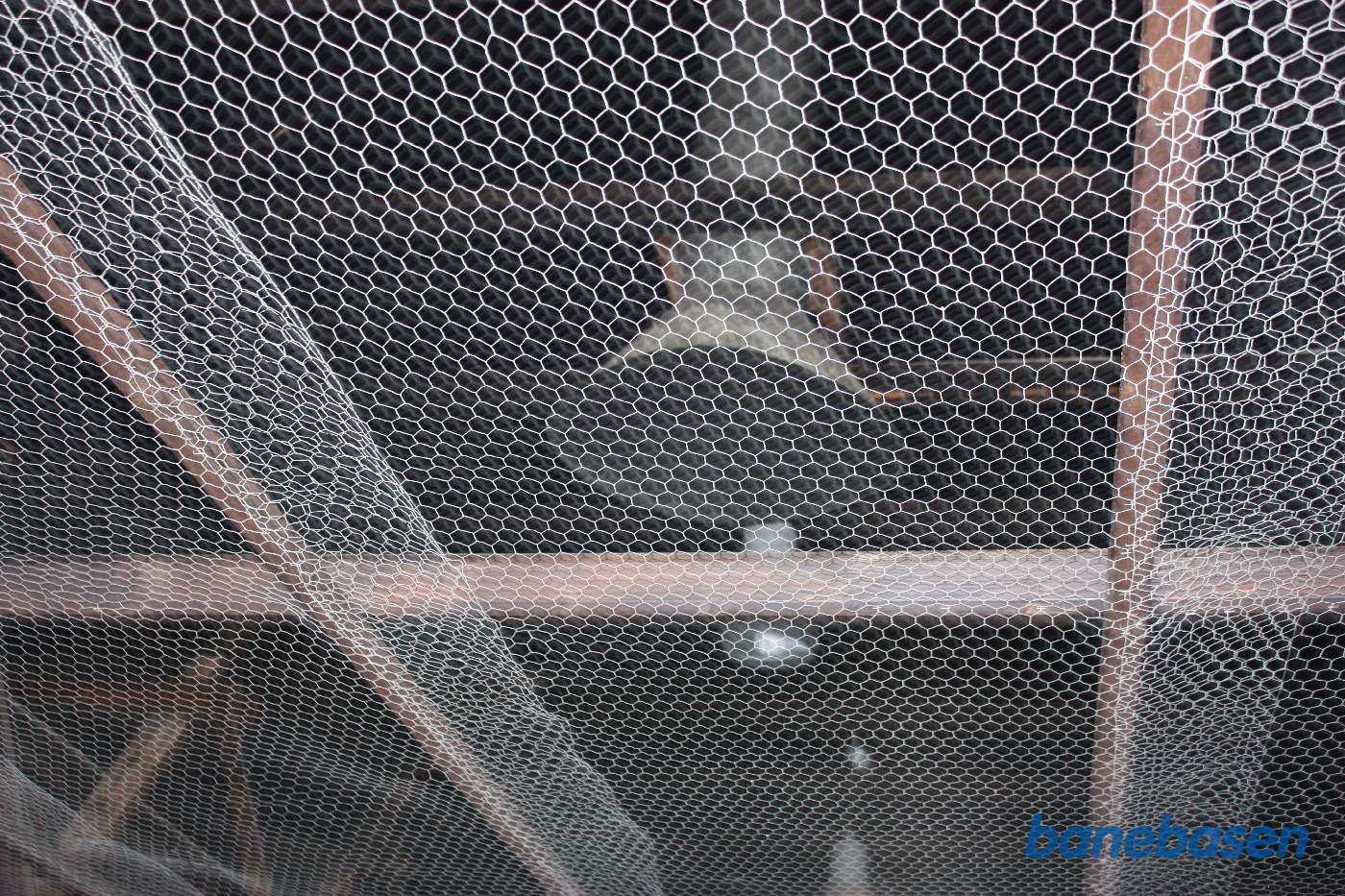 Oppe over hønsenettet ses det gamle røgaftræk til damplokomotiver