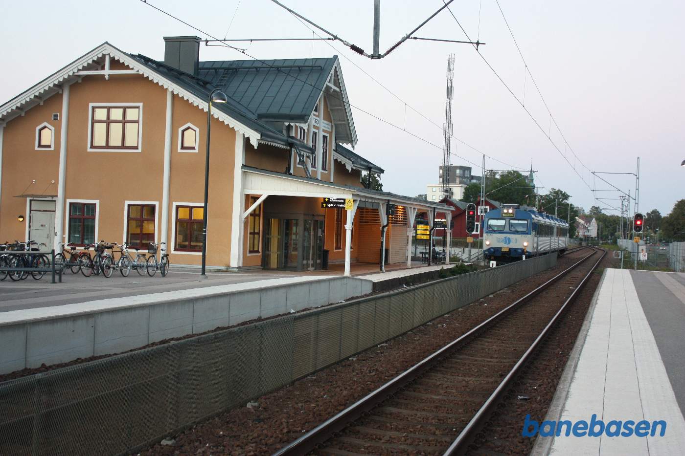 Stationsbygningen med lokaltog på vej ind i spor 1