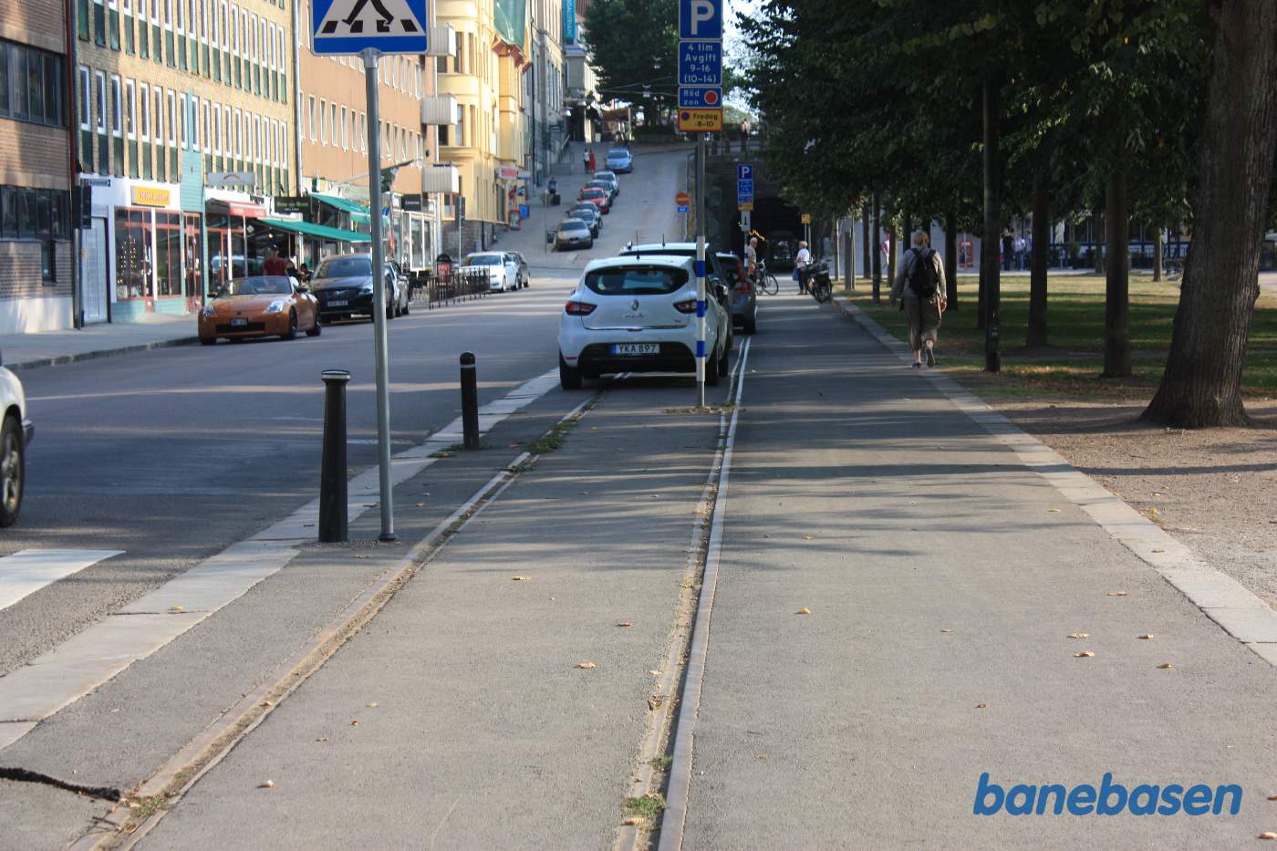 Vi følger resterne af havnebanen, der løber ned langs gaden, hvor der nu er parkerede biler, og fortsætter ind i en lang tunnel under byen