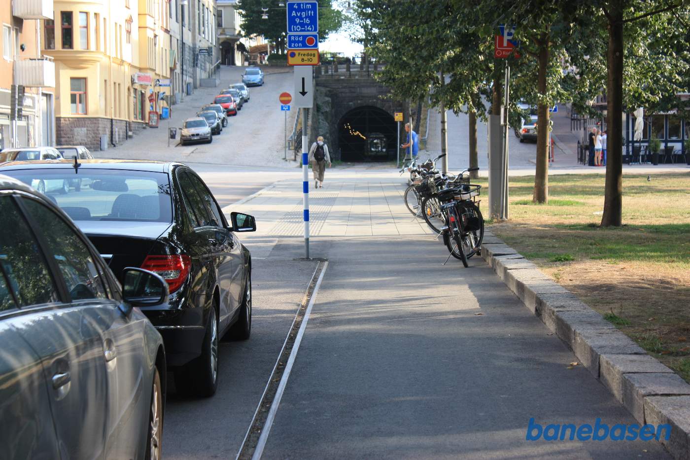 Vi følger resterne af havnebanen, der løber ned langs gaden, hvor der nu er parkerede biler, og fortsætter ind i en lang tunnel under byen