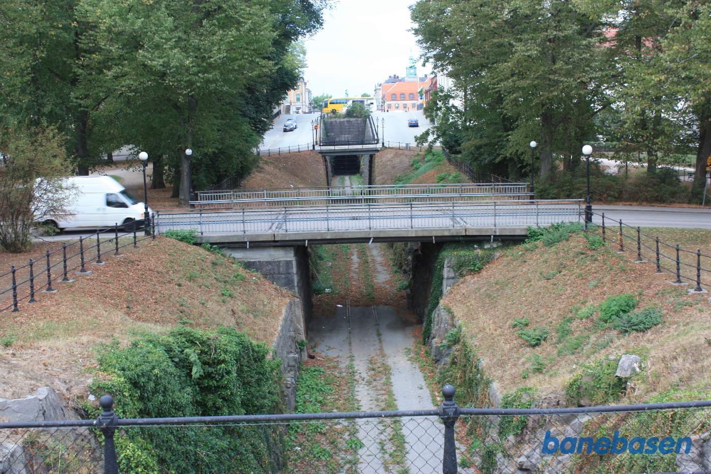 Vi står på en vejbro og kigger mod stationen, bytorvet ovenpå tunnelen