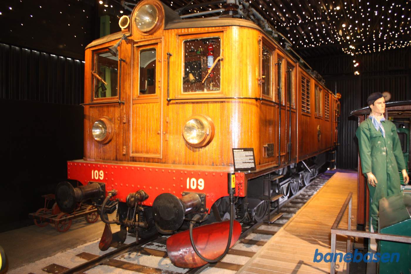 Et elektrisk lokomotiv med teaktræsbeklædning inde i udstillingshallen