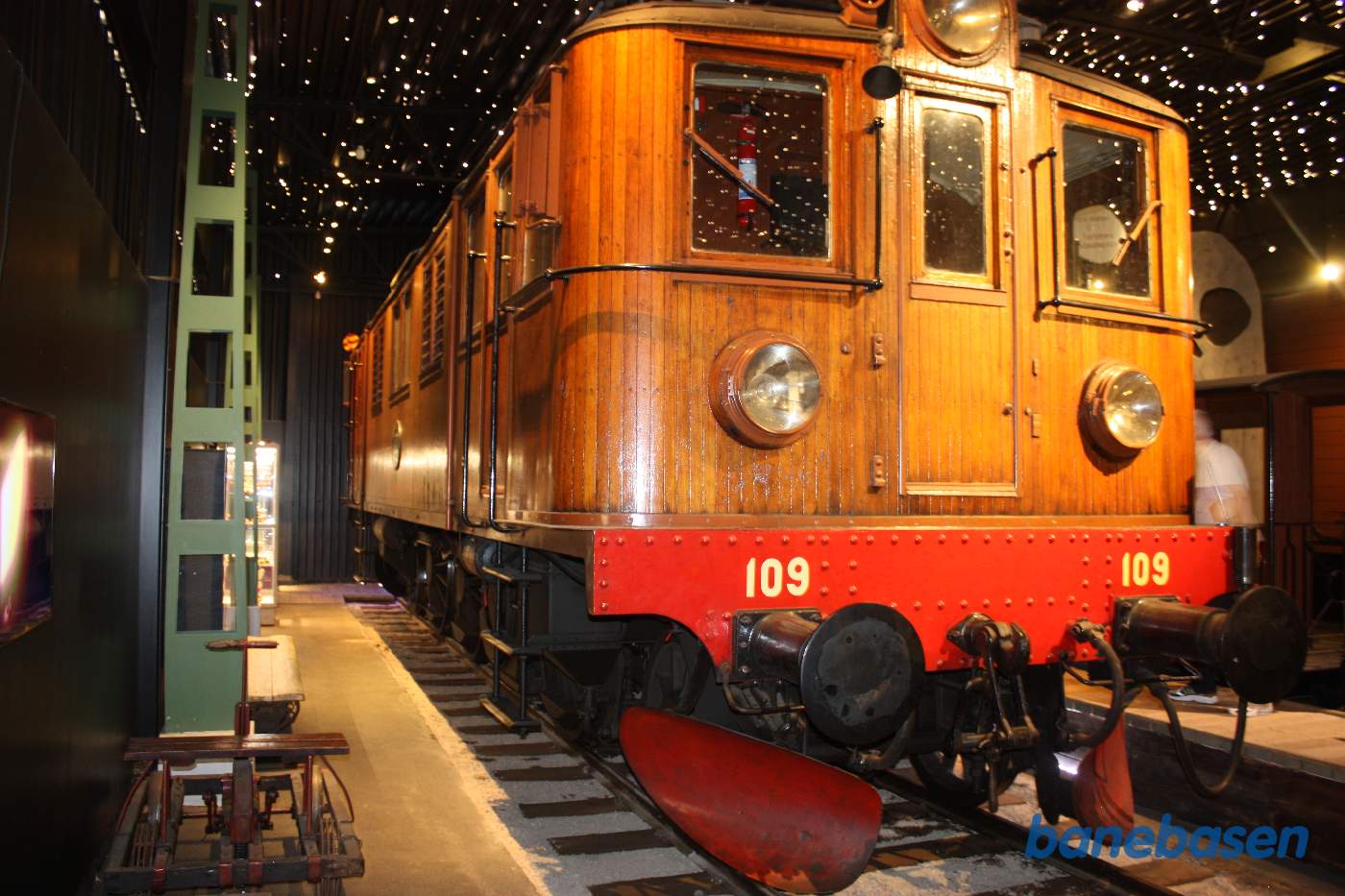 Et elektrisk lokomotiv med teaktræsbeklædning inde i udstillingshallen