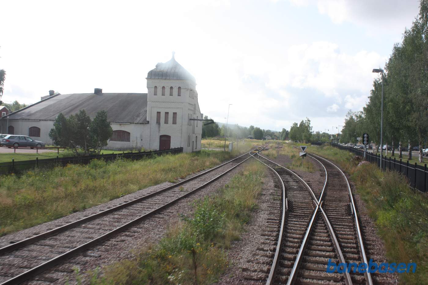 Toget suser igennem Orsa station, her set ud ad bagruden, bagsiden af rundremisen ses inde til venstre