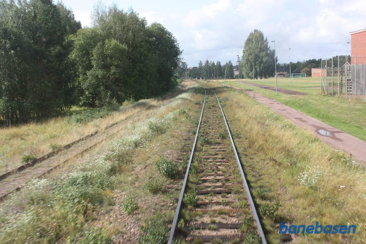Toget suser igennem Orsa station, her set ud ad bagruden, sportspladsen ses inde til højre