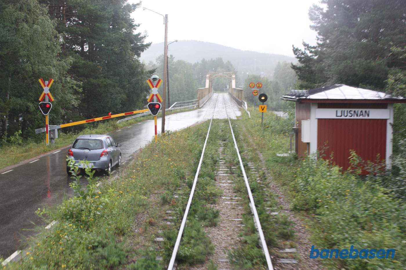 Toget har netop passeret den fælles jernbane og vejbro: Mankellbron. En bil holder og venter på at toget kommer helt fri af broen