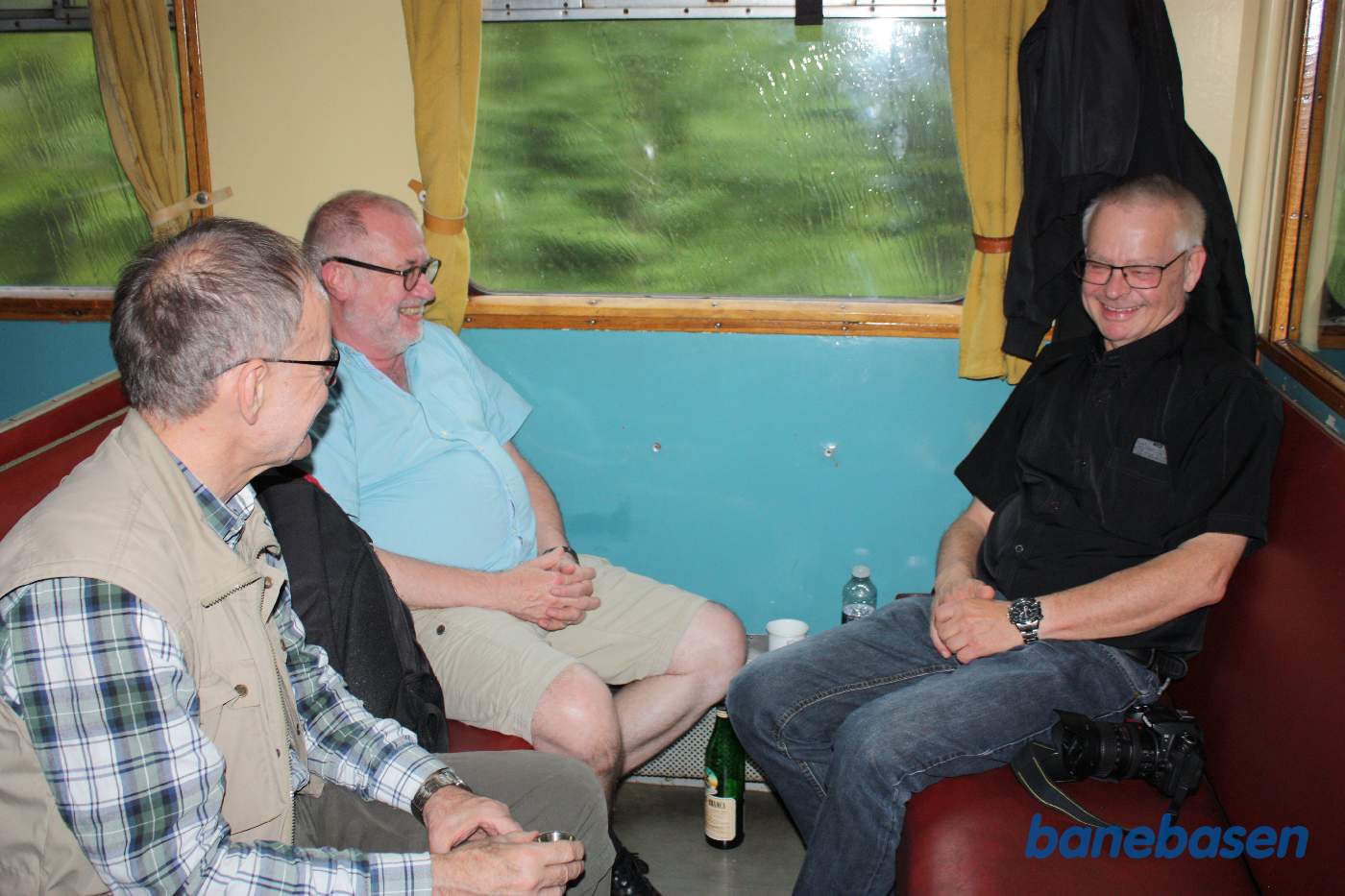 Inde i toget er stemningen, med små drinks, høj