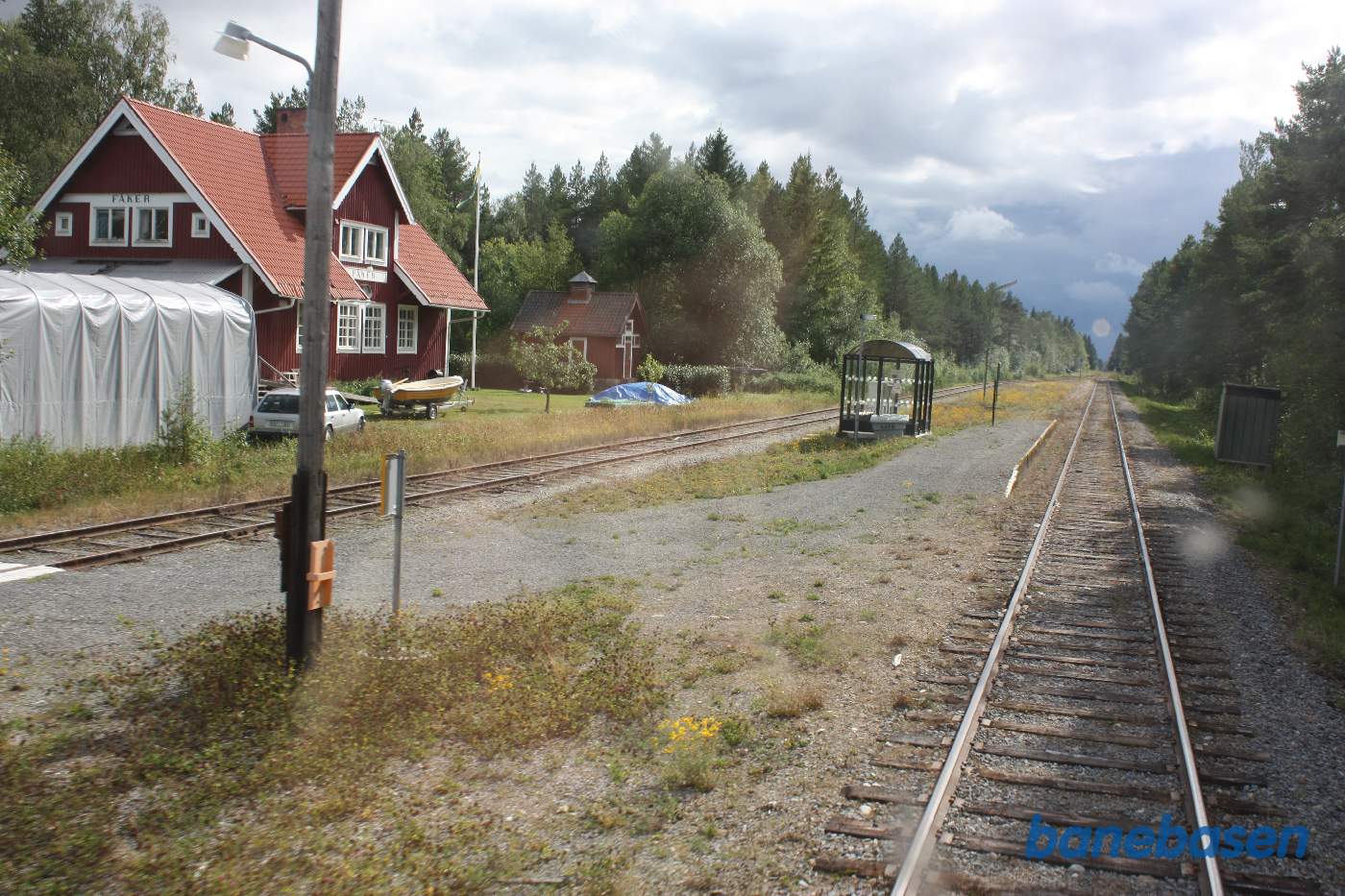 Et bagskud mens toget suser gennem Fåker station, stationsbygningen inde til venstre