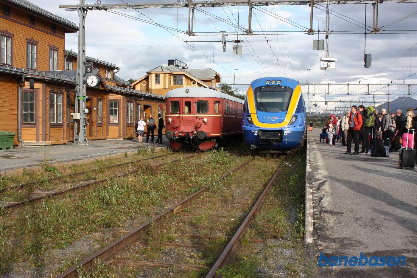 2 persontog ved perron. Passagerer der skal videre mod Trondheim står på midterperronen og venter på toget fra Trondheim