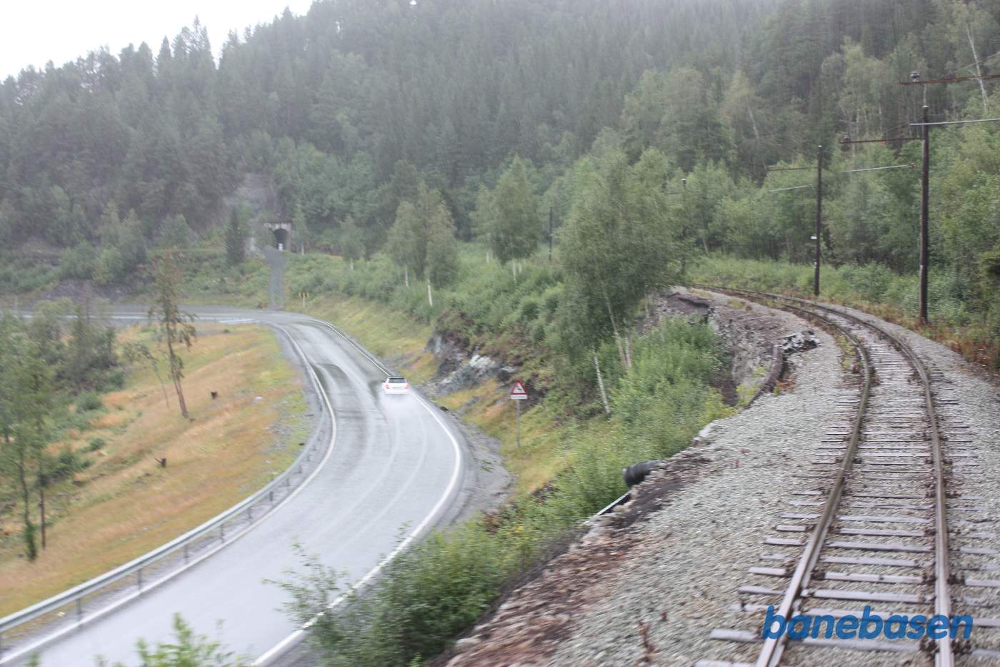 Et bagskud fra bagerste endeperron, et sted på strækningen mellem Svorkmo og Løkken Værk, tunnelen ses ude til venstre mens vejen må udenom bjerget